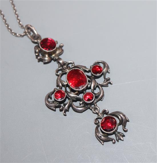 An early-mid 20th century white metal and garnet set quatrefoil shaped drop pendant, on a long fine link white metal chain,